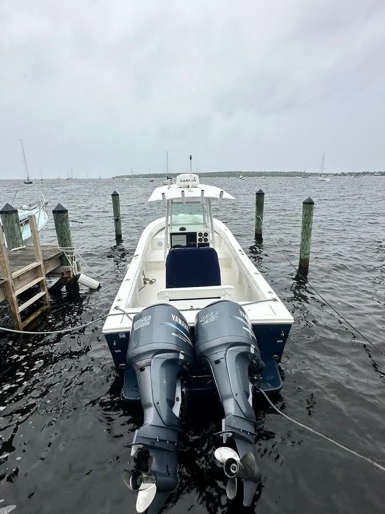 Slide: The Image of 2005 Regulator 26 Forward Seating boat docked with twin outboard motors. - 1