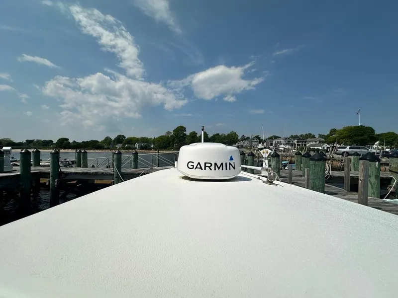Slide: The Image of 2005 Regulator 26 Forward Seating boat with Garmin equipment at a dock under a blue sky. - 10
