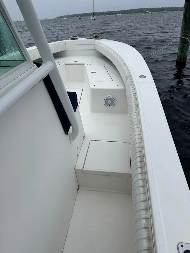 Slide: The Image of 2005 Regulator 26 Forward Seating boat on water, showcasing sleek white deck design. - 12