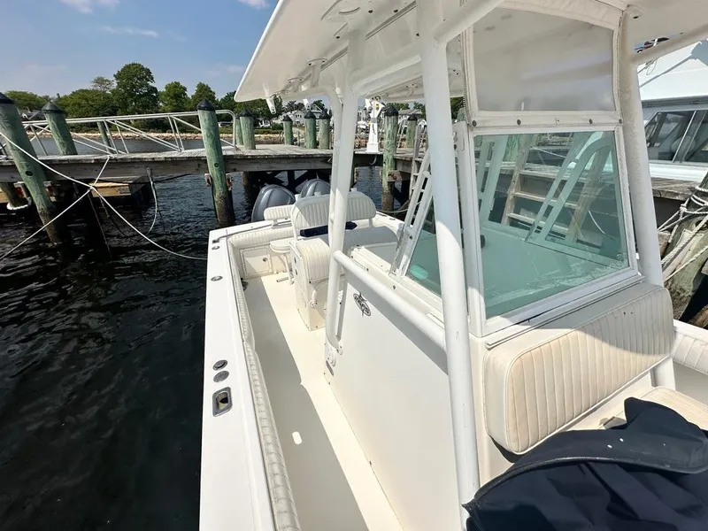 Slide: The Image of 2005 Regulator 26 Forward Seating boat docked at marina, showcasing spacious deck and seating. - 13