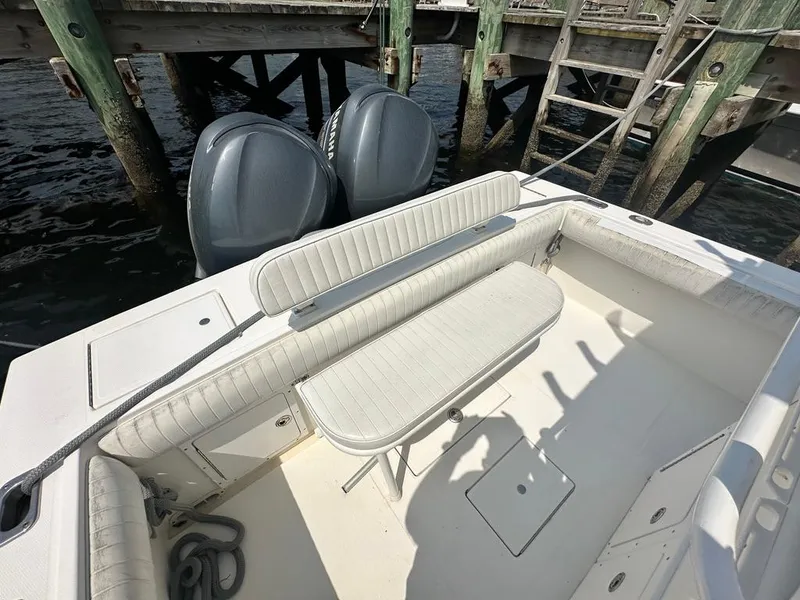 Slide: The Image of 2005 Regulator 26 Forward Seating boat with dual engines docked by wooden pier. - 15