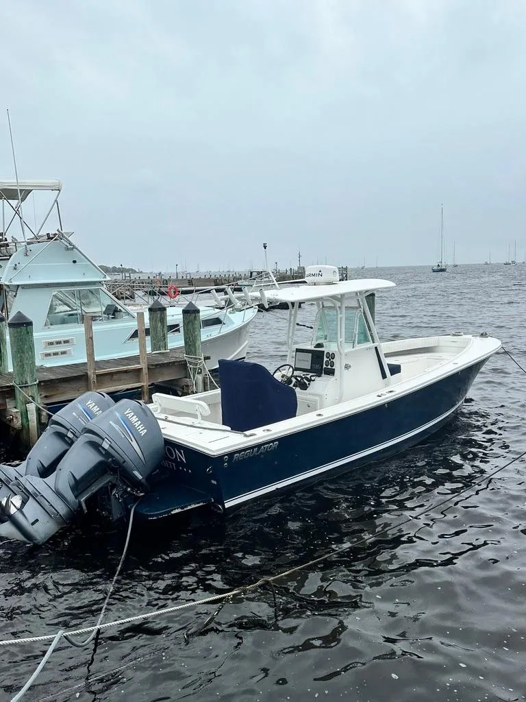 Slide: The Image of 2005 Regulator 26 Forward Seating boat docked with twin Yamaha engines. - 2