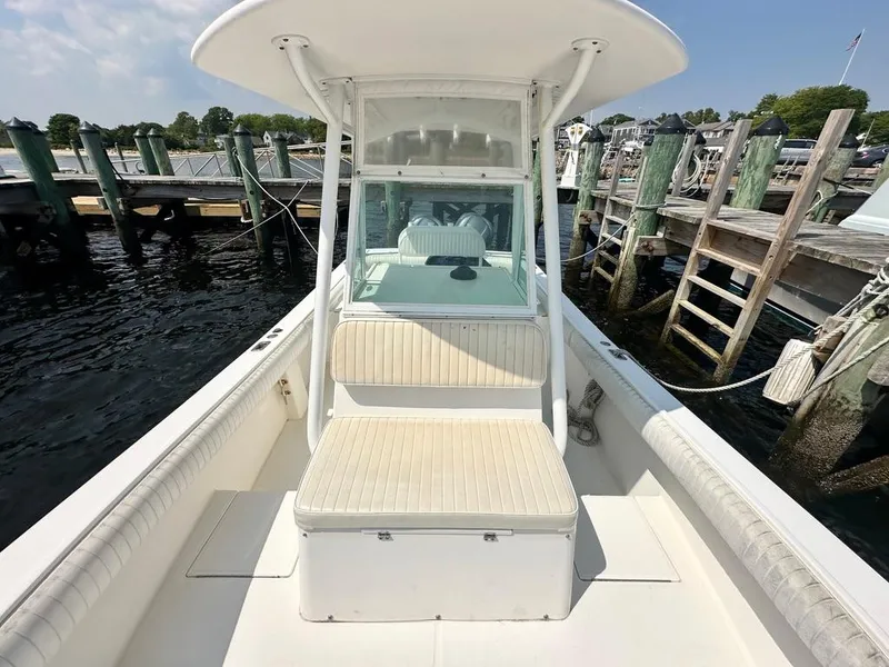 Slide: The Image of 2005 Regulator 26 Forward Seating boat docked at a marina, showcasing spacious seating and helm. - 6
