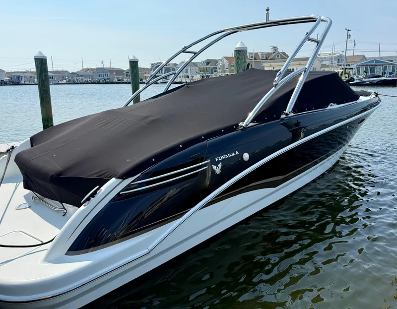 The Image of 2011 Formula 270 Bowrider boat docked, covered with black tarp, in a marina setting. - 0