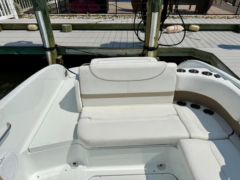Slide: The Image of 2011 Formula 270 Bowrider boat interior with white seating at dock. - 12