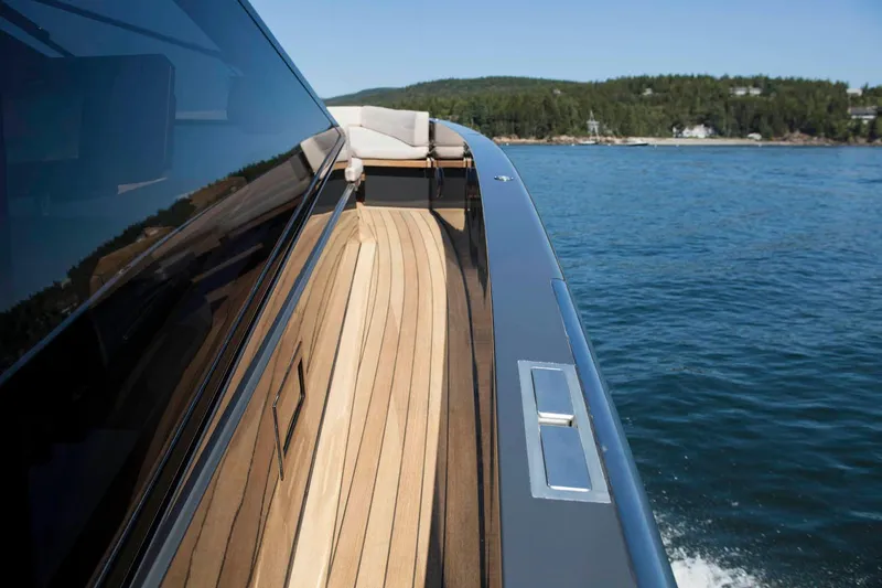 Slide: The Image of Wallypower 52 yacht cruising on a serene lake, showcasing sleek design and wooden deck. - 10