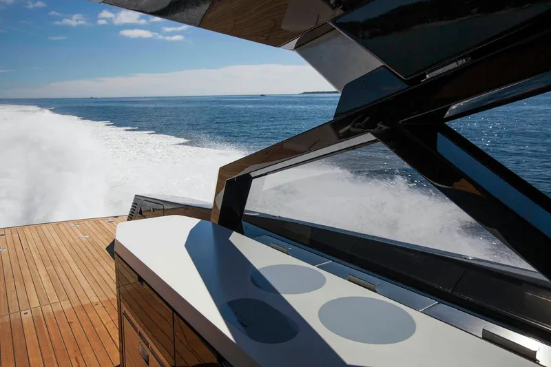 Slide: The Image of Wallypower 52 yacht cruising on open sea, showcasing sleek design and wooden deck. - 16