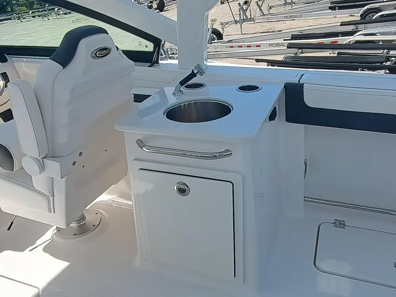 Slide: The Image of 2025 Robalo R257 Dual Console boat interior with sink and seating area. - 10