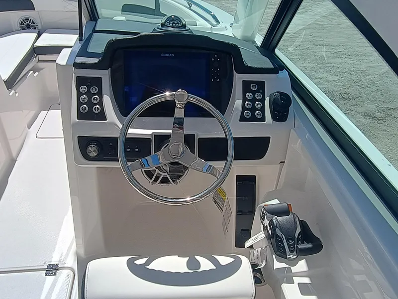 Slide: The Image of 2025 Robalo R257 Dual Console boat dashboard with steering wheel and control panel. - 13