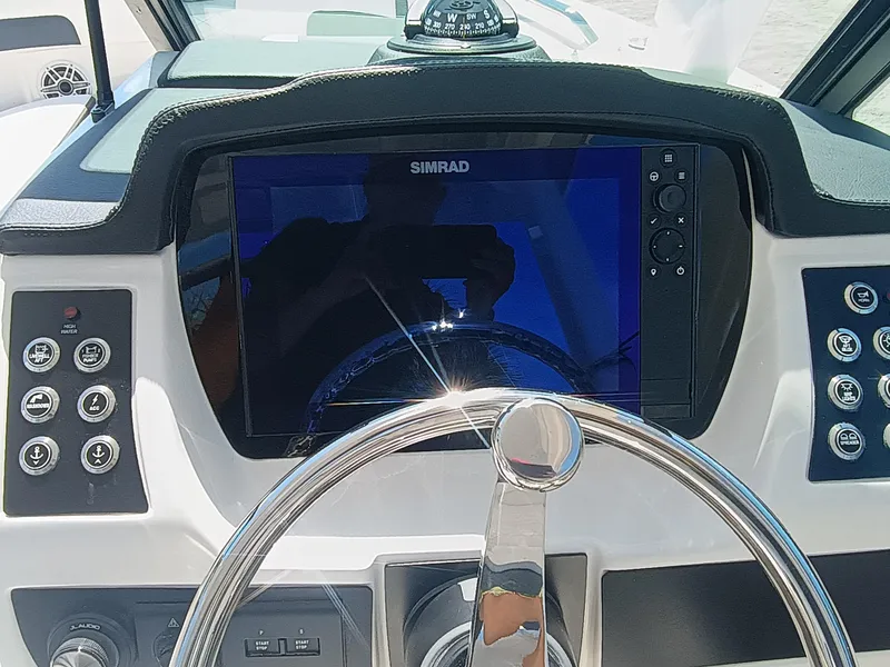 Slide: The Image of 2025 Robalo R257 Dual Console dashboard with Simrad display and steering wheel. - 16