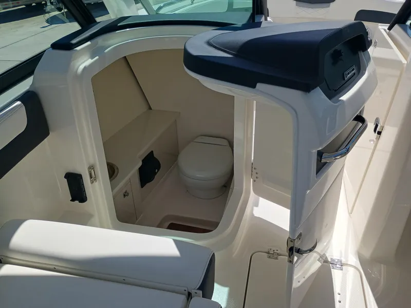 Slide: The Image of 2025 Robalo R257 Dual Console boat interior with compact marine toilet. - 25