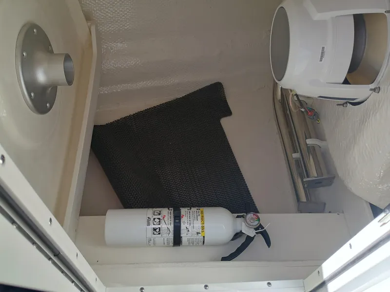 Slide: The Image of 2025 Robalo R257 Dual Console interior with fire extinguisher and storage compartment. - 30