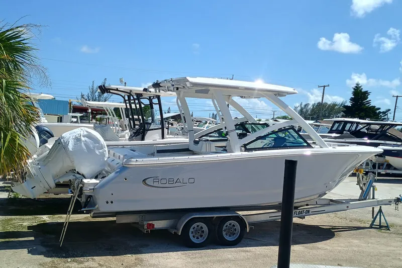 Slide: The Image of 2025 Robalo R257 Dual Console boat on trailer, sunny day, marina background. - 4