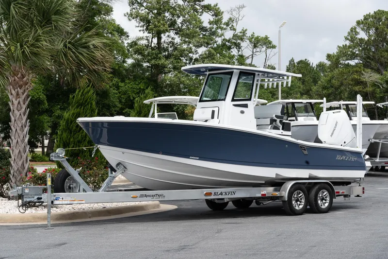 Slide: The Image of 2026 Blackfin 262 HB boat on trailer, parked outdoors with trees in background. - 2