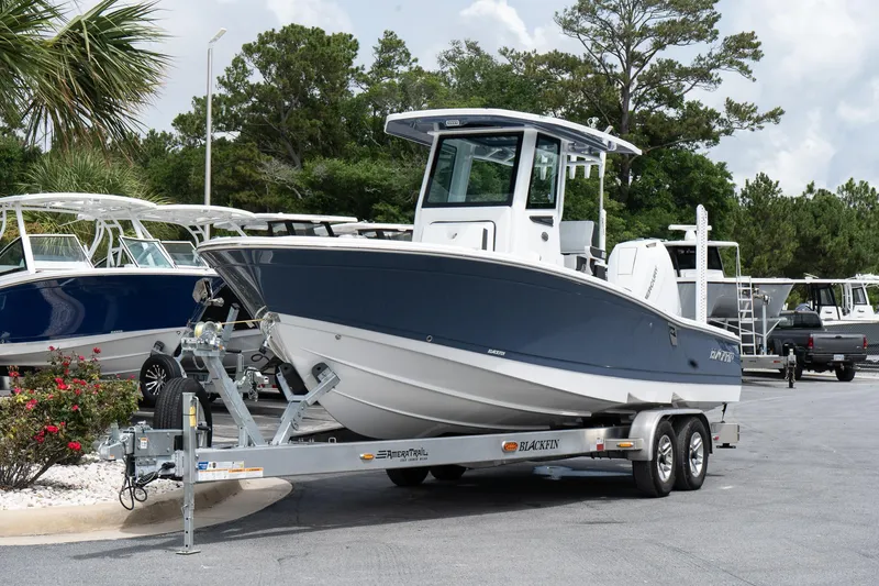 Slide: The Image of 2026 Blackfin 262 HB boat on trailer, parked outdoors, surrounded by trees and other boats. - 3