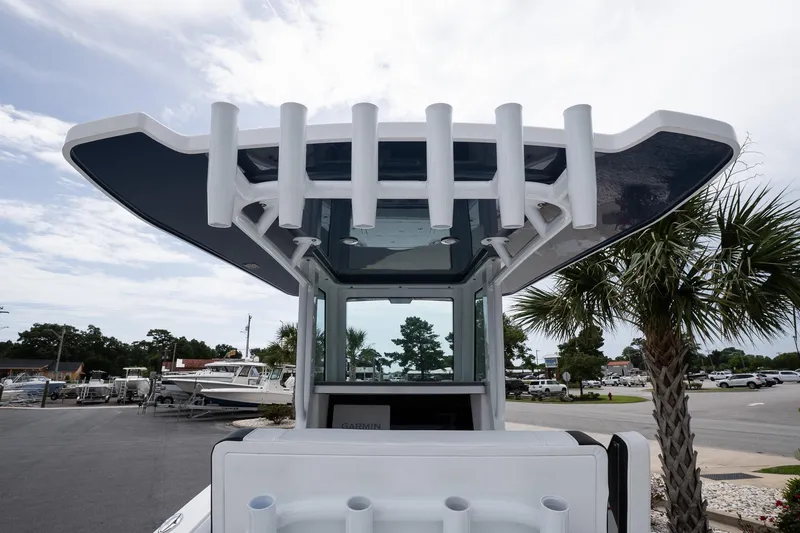 Slide: The Image of 2026 Blackfin 262 HB boat with T-top and rod holders, parked near palm trees. - 30
