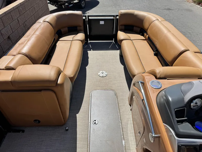 Slide: The Image of 2021 Regency 230 LE3 pontoon boat interior with tan seating and carpeted floor. - 11