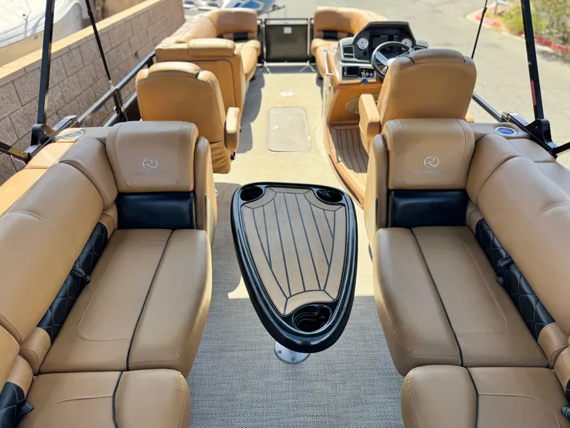 Slide: The Image of 2021 Regency 230 LE3 boat interior with tan leather seating and central table. - 22