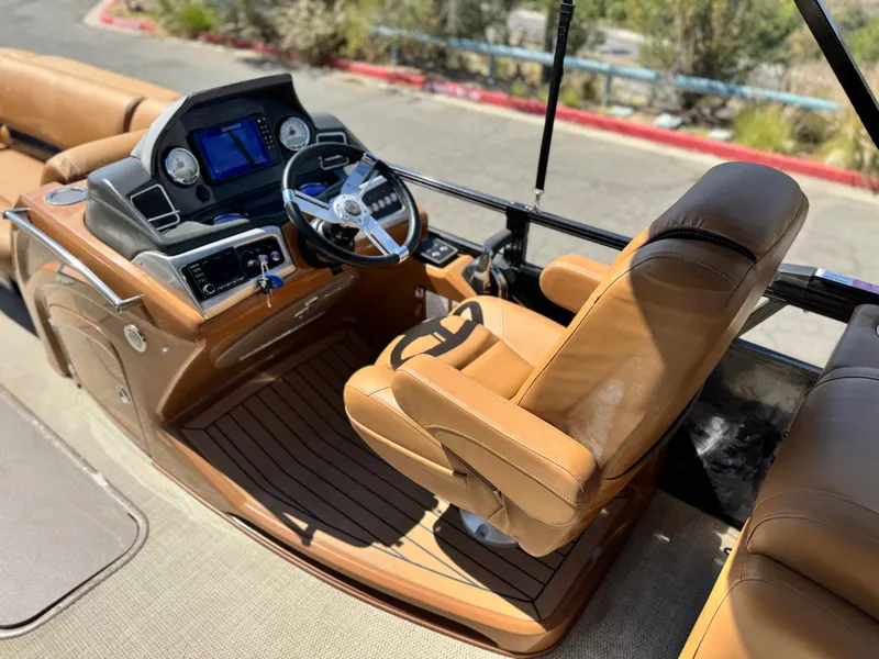 Slide: The Image of Luxurious 2021 Regency 230 LE3 boat interior with leather captain's chair and modern dashboard. - 23