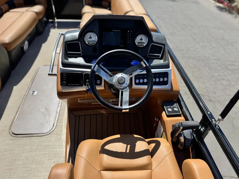 Slide: The Image of 2021 Regency 230 LE3 boat dashboard with steering wheel and control panel. - 24