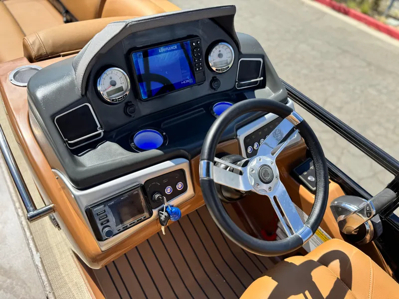 Slide: The Image of 2021 Regency 230 LE3 boat dashboard with steering wheel and navigation system. - 25