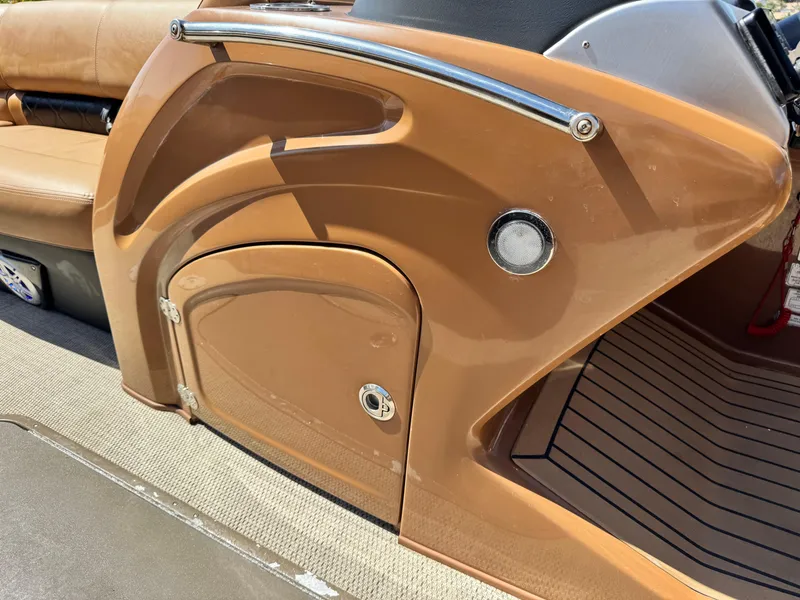 Slide: The Image of 2021 Regency 230 LE3 boat interior with tan paneling and seating. - 26