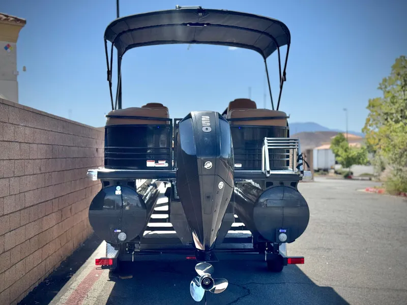 Slide: The Image of 2021 Regency 230 LE3 pontoon boat with outboard motor, parked outdoors. - 4