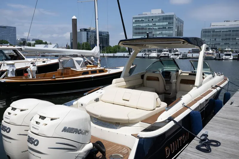 Slide: The Image of 2021 Chris-Craft Launch GT boat docked, featuring luxurious seating and twin Mercury engines. - 24
