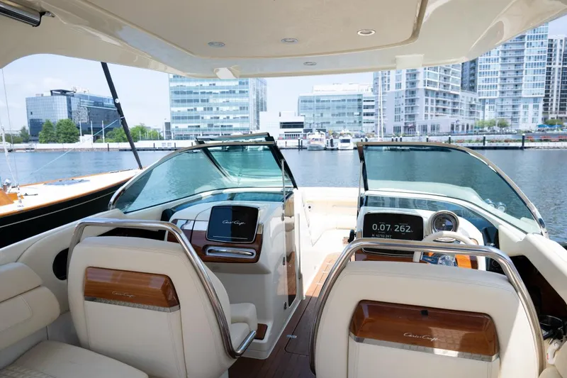 Slide: The Image of 2021 Chris-Craft Launch GT interior with modern dashboard, luxurious seating, and waterfront cityscape view. - 35