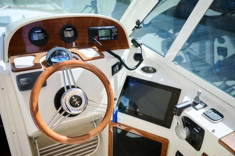 Slide: The Image of Helm of 2016 Hunt Yachts Harrier 26 with wooden steering wheel and modern controls. - 16