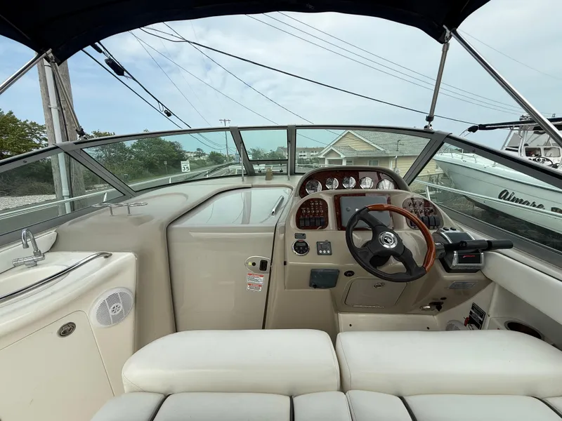 Slide: The Image of 2006 Sea Ray 300 Sundancer cockpit with steering wheel and dashboard controls. - 16