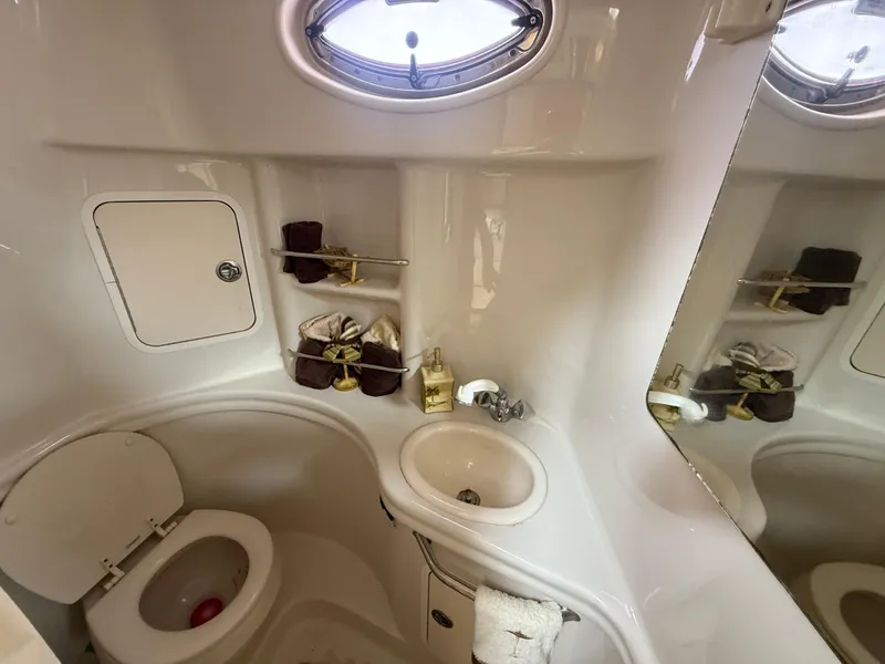Slide: The Image of 2006 Sea Ray 300 Sundancer bathroom with sink, toilet, and storage shelves. - 17