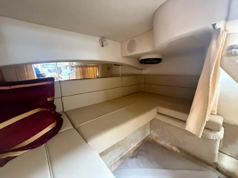 Slide: The Image of 2006 Sea Ray 300 Sundancer cabin interior with beige seating and red cushions. - 25
