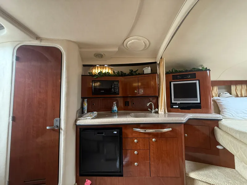 Slide: The Image of Interior of 2006 Sea Ray 300 Sundancer with kitchenette and cozy seating area. - 27
