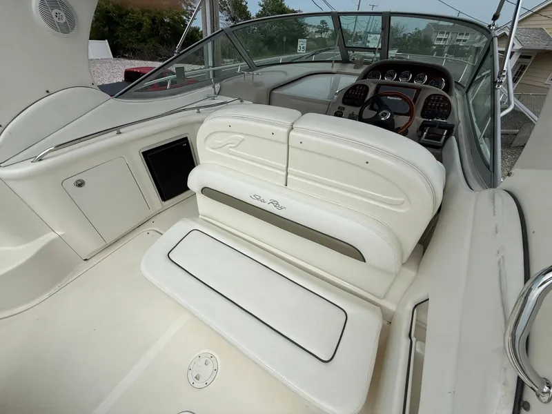 Slide: The Image of 2006 Sea Ray 300 Sundancer boat interior with white seating and dashboard view. - 3