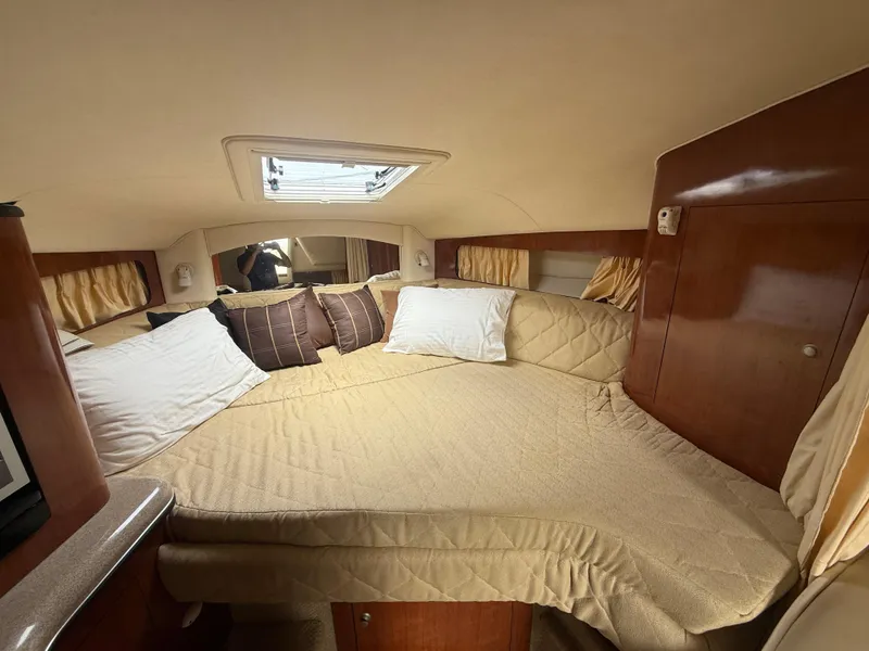 Slide: The Image of Interior cabin of 2006 Sea Ray 300 Sundancer with cozy bed and wooden accents. - 30