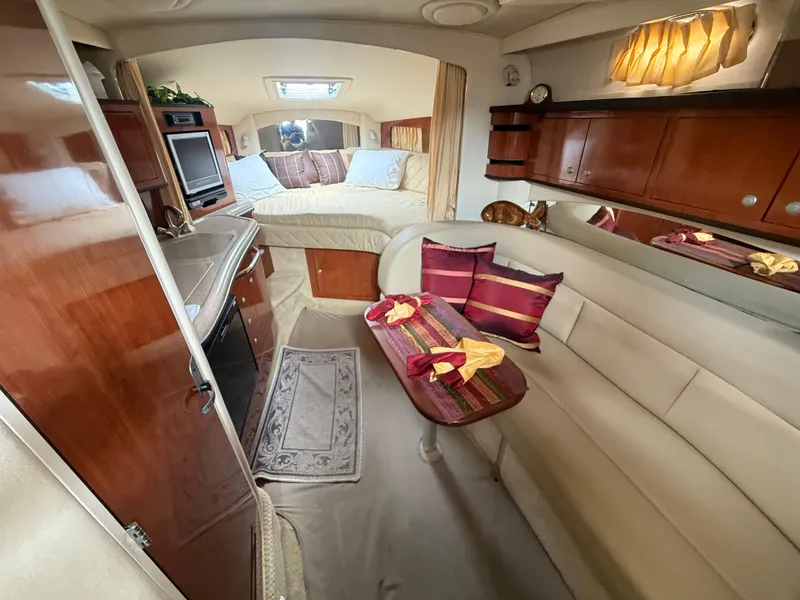 Slide: The Image of 2006 Sea Ray 300 Sundancer interior with cozy seating, kitchenette, and bed. - 32