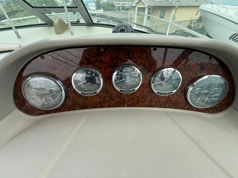 Slide: The Image of Dashboard of 2006 Sea Ray 300 Sundancer with five gauges and wood paneling. - 34