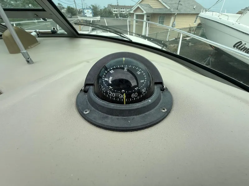 Slide: The Image of Compass on 2006 Sea Ray 300 Sundancer boat dashboard, with marina view. - 35