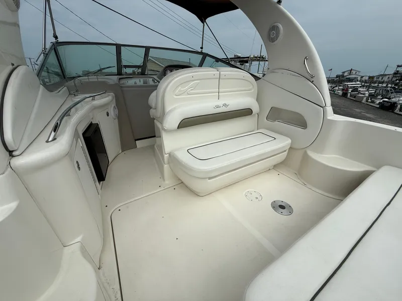 Slide: The Image of 2006 Sea Ray 300 Sundancer boat interior with seating and helm, docked at marina. - 41