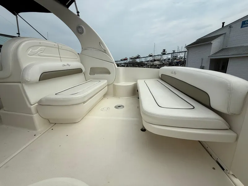 Slide: The Image of 2006 Sea Ray 300 Sundancer boat interior with white seating and marina view. - 42