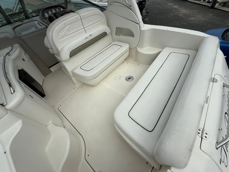 Slide: The Image of 2006 Sea Ray 300 Sundancer boat interior with white seating and helm. - 43