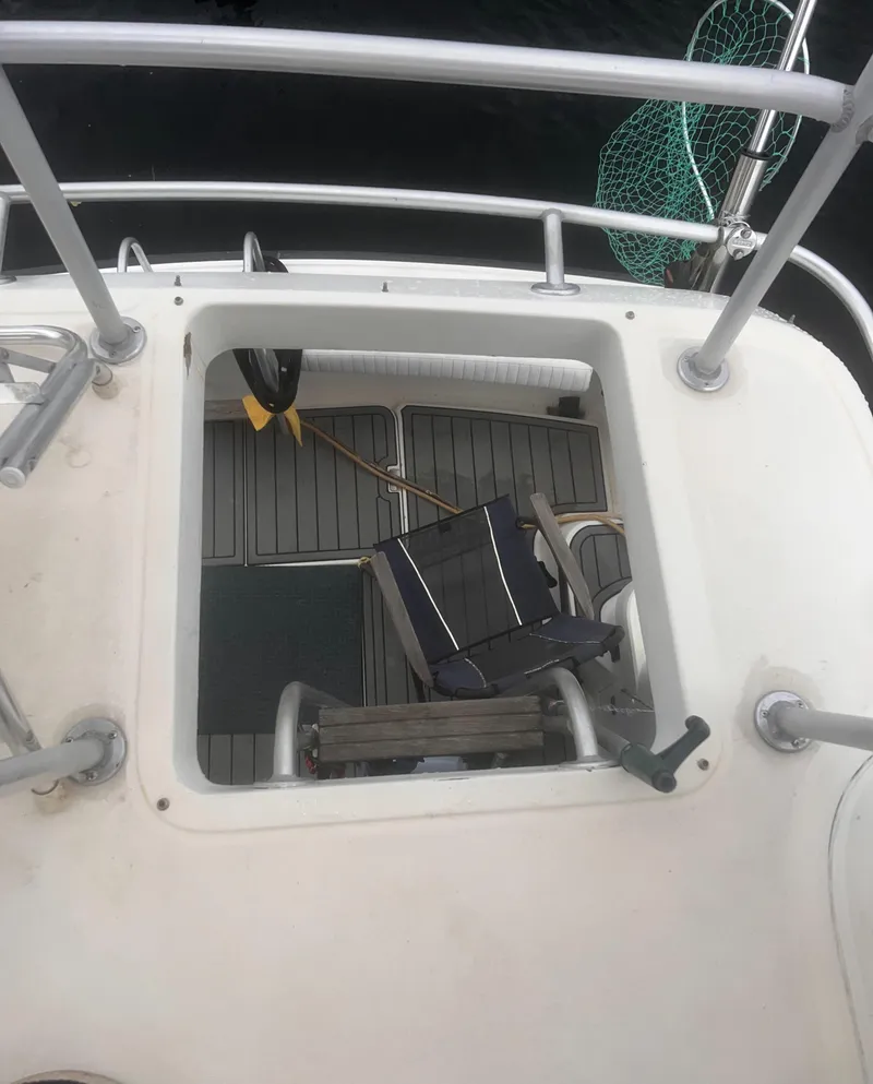 Slide: The Image of 1990 Luhrs 3400 Motor Yacht deck with open hatch and chair. - 10