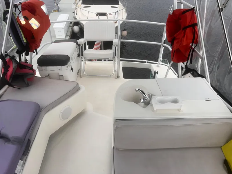 Slide: The Image of 1990 Luhrs 3400 Motor Yacht deck with seating, life jackets, and a small sink. - 11