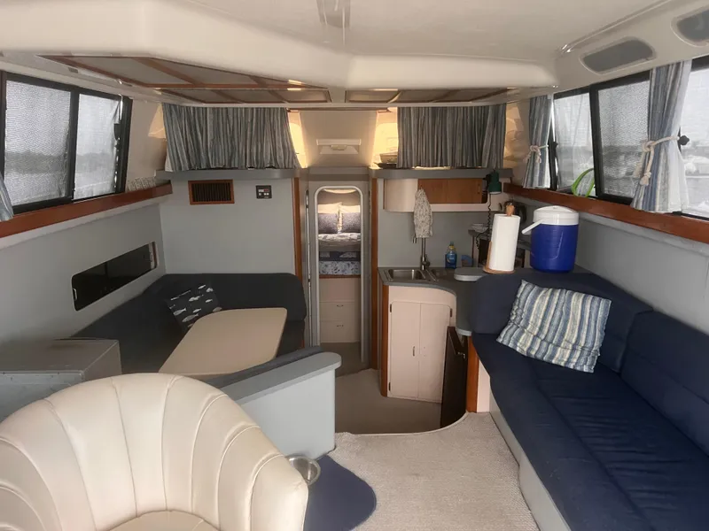 Slide: The Image of Interior of 1990 Luhrs 3400 Motor Yacht with seating, kitchenette, and cozy decor. - 14