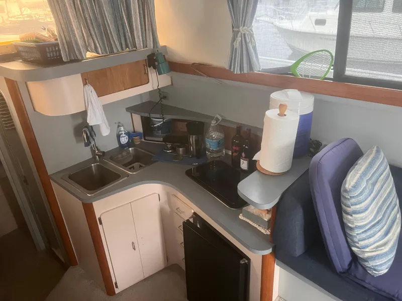 Slide: The Image of Interior of 1990 Luhrs 3400 Motor Yacht kitchen with sink, stove, and seating area. - 18