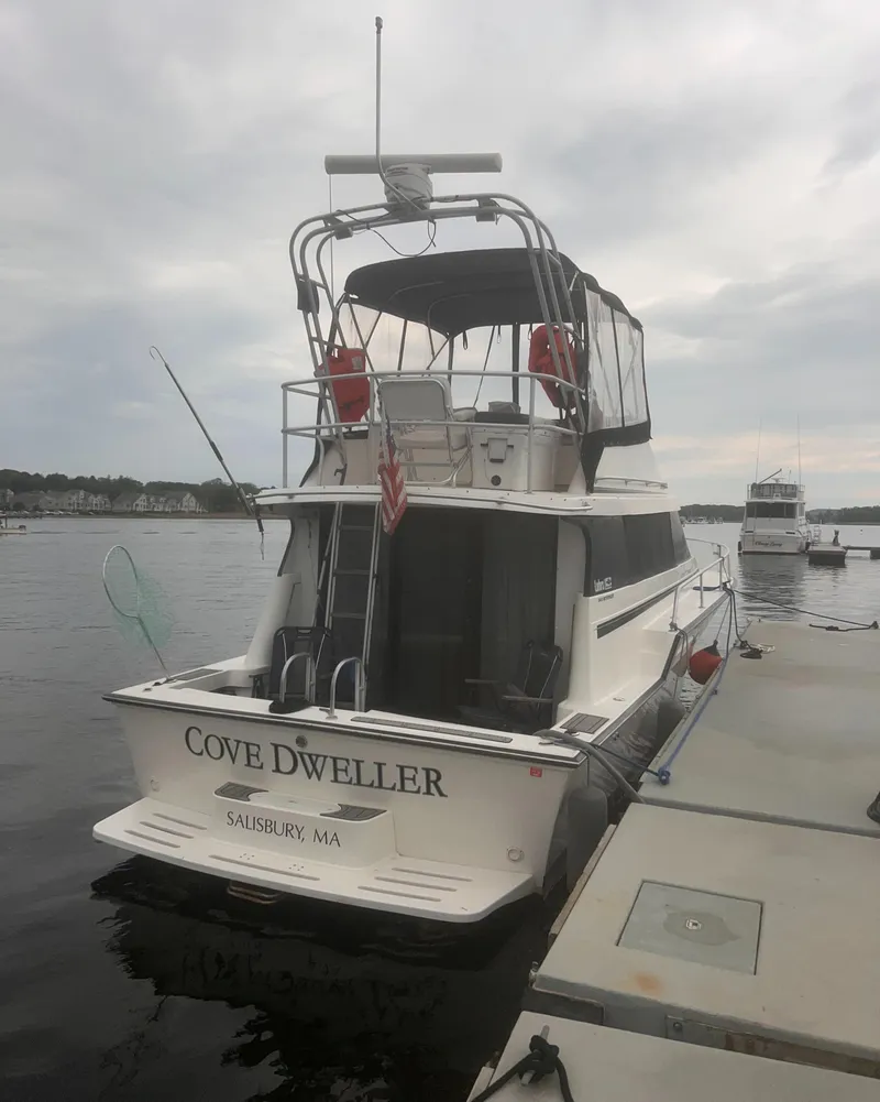 Slide: The Image of 1990 Luhrs 3400 Motor Yacht docked, named "Cove Dweller," in a marina setting. - 2