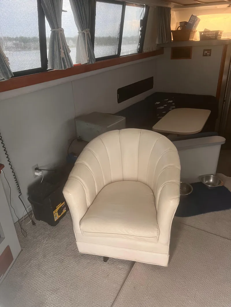 Slide: The Image of 1990 Luhrs 3400 Motor Yacht interior with white armchair and seating area. - 21