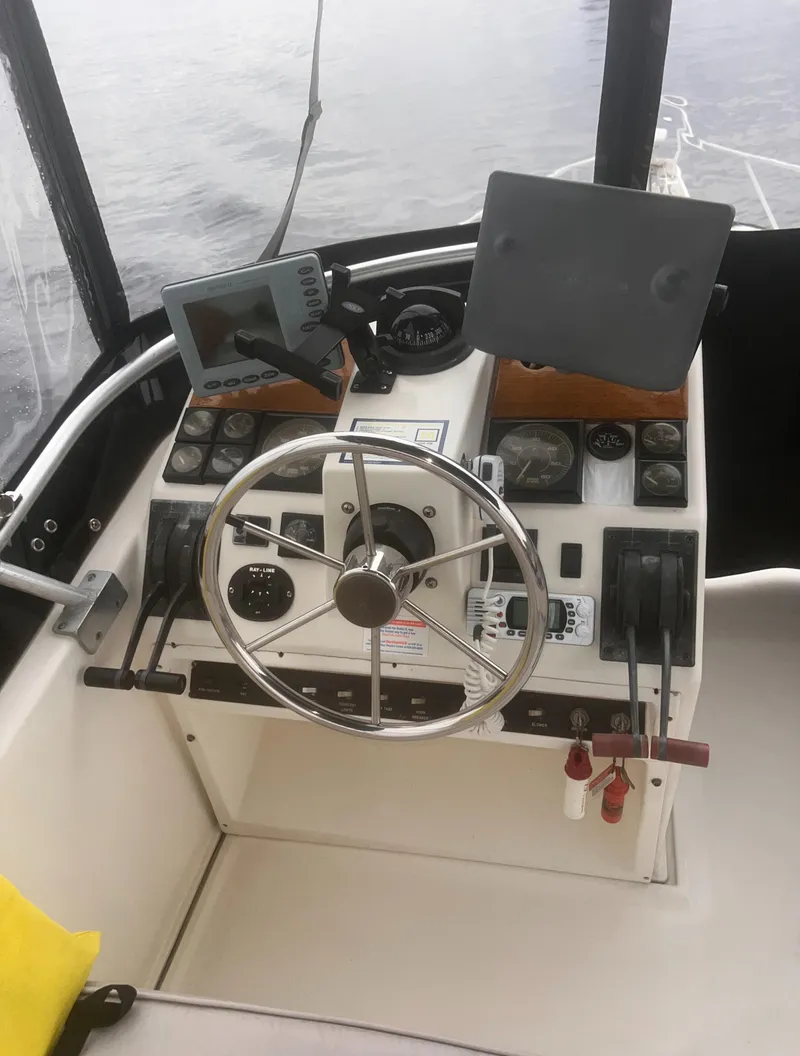 Slide: The Image of 1990 Luhrs 3400 Motor Yacht helm with steering wheel and navigation instruments. - 5