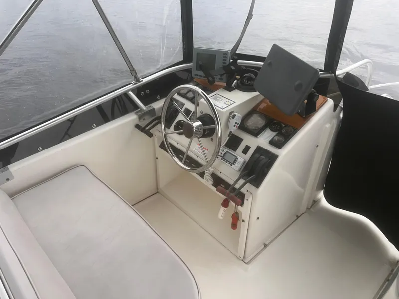 Slide: The Image of 1990 Luhrs 3400 Motor Yacht helm with steering wheel, navigation equipment, and seating. - 6